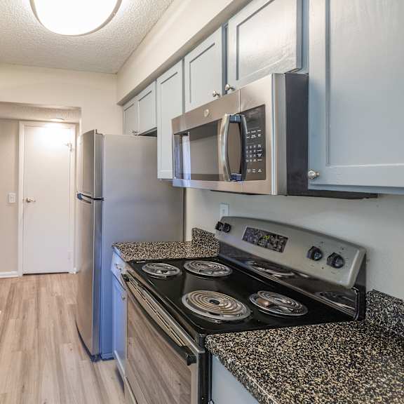 a kitchen with a stove, sink, and refrigerator.