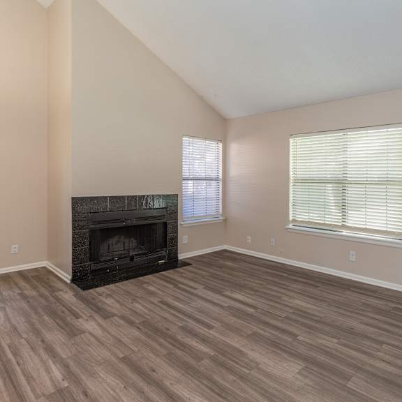 a room with a fireplace and wood flooring.