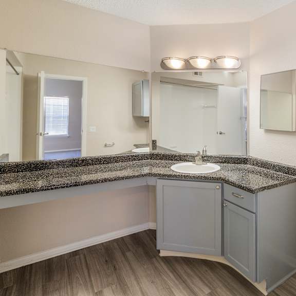 a bathroom with a sink, toilet, and a mirror.