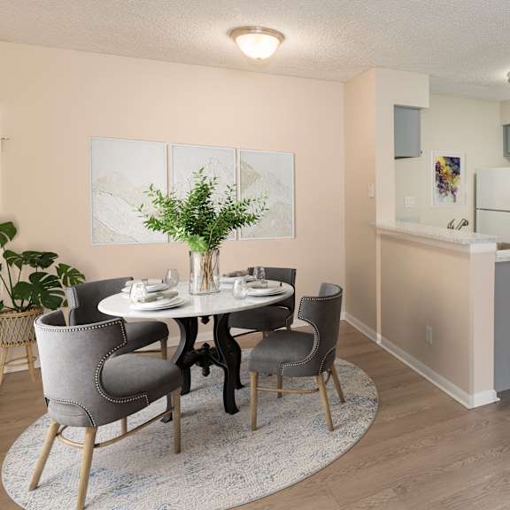 a dining room with a white table and grey chairs.