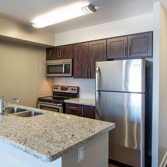 a kitchen with a granite countertop and stainless steel appliances.