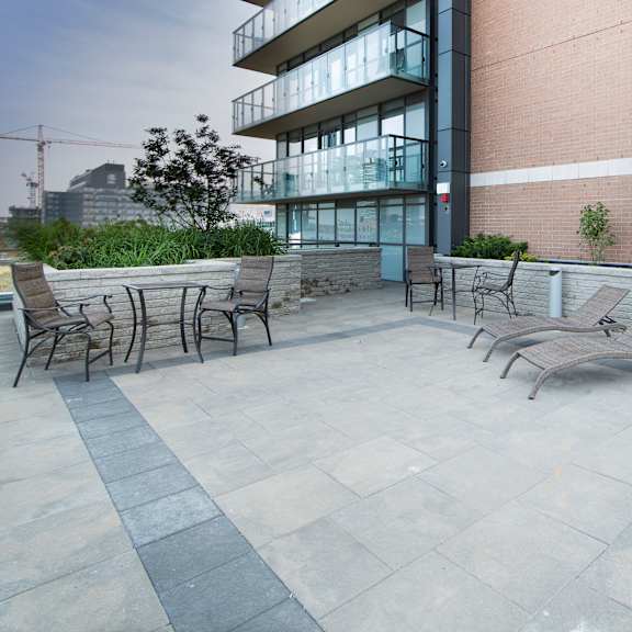 a patio with a table and chairs is in front of a building.