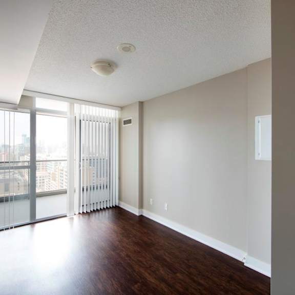 a room with a sliding glass door leading to a balcony.