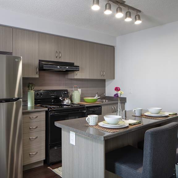 a modern kitchen with a dining table set for two.