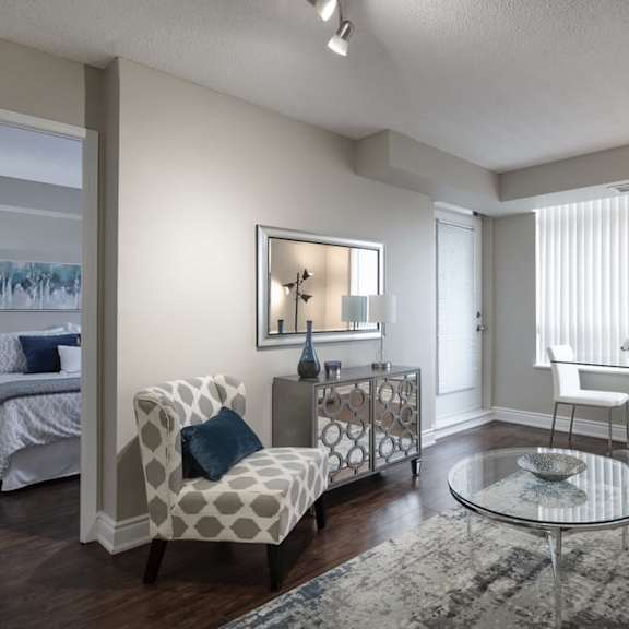 a living room with a couch and a chair in front of a window