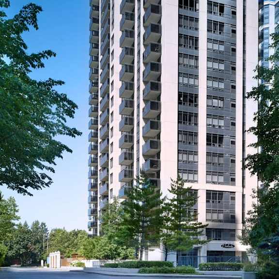 an apartment building with a parking lot in front of it