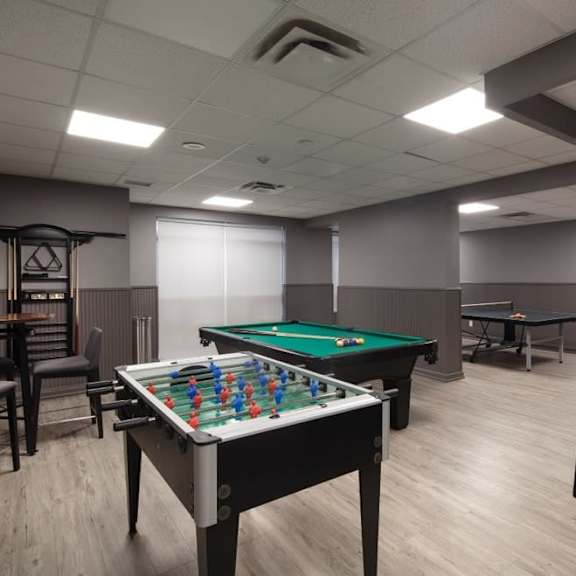 a games room with two pool tables and a ping pong table