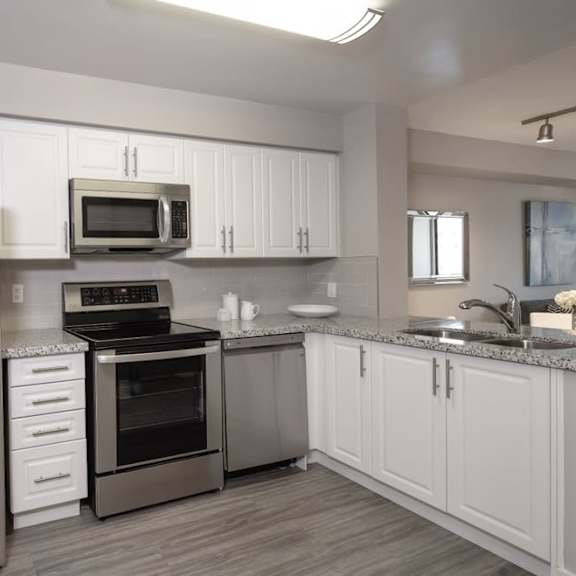 a kitchen with white cabinets and stainless steel appliances