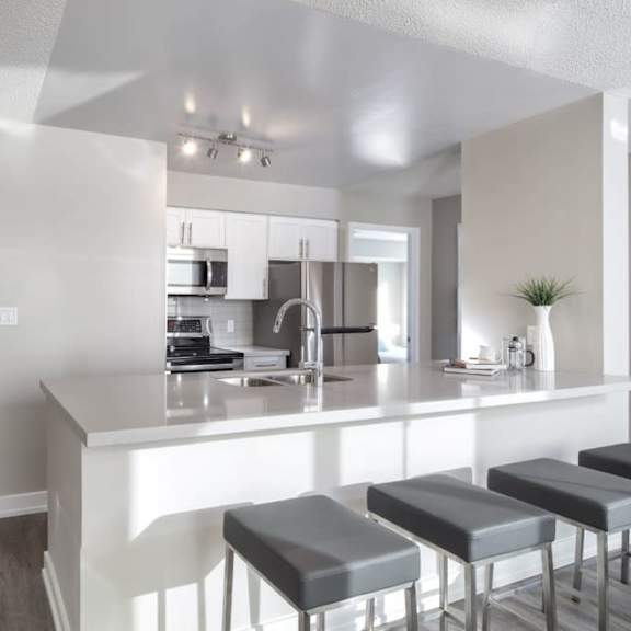 a kitchen with an island and stools in front of it