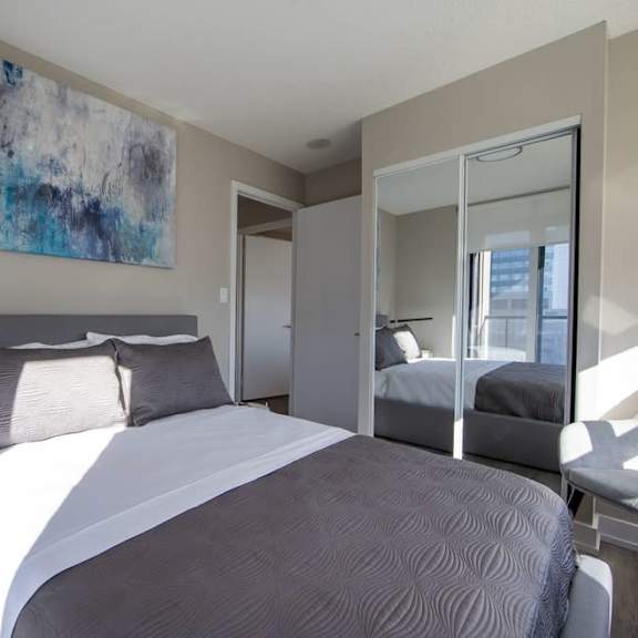 a bedroom with a large bed and a large mirror