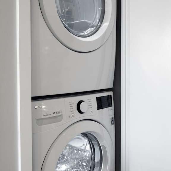 a front loading washer and dryer in a white utility room