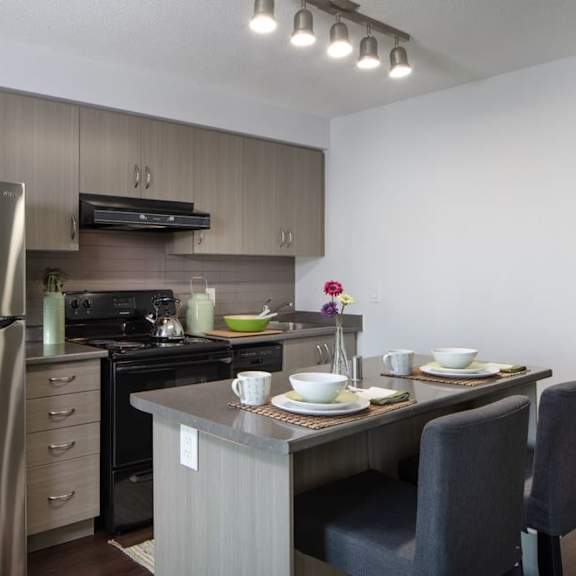 a kitchen with a refrigerator freezer next to a stove top oven