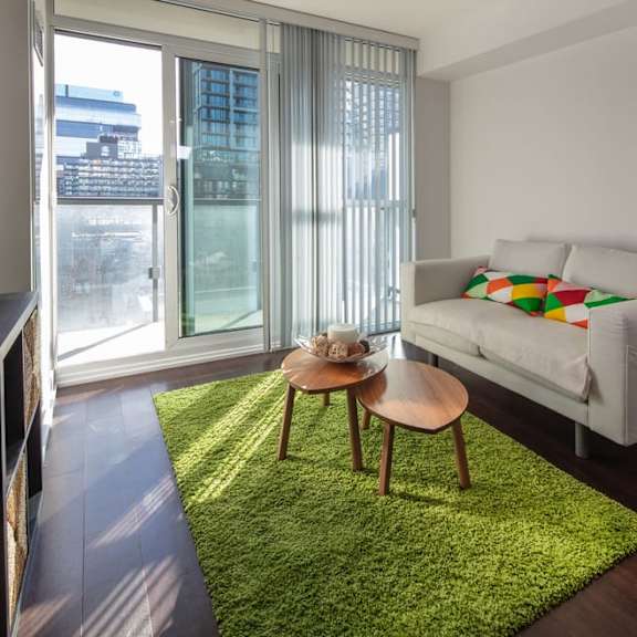 a living room with a green rug and a white couch