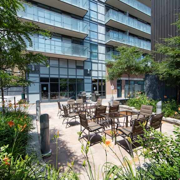 a courtyard with tables and chairs in front of a building