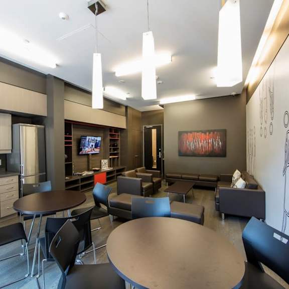 a lounge area with tables and chairs and a television in the background