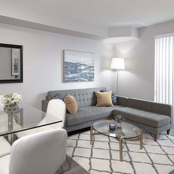 a living room with a gray couch and a glass coffee table