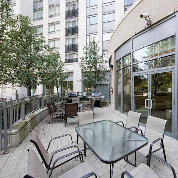 a patio with a table and chairs in front of a building
