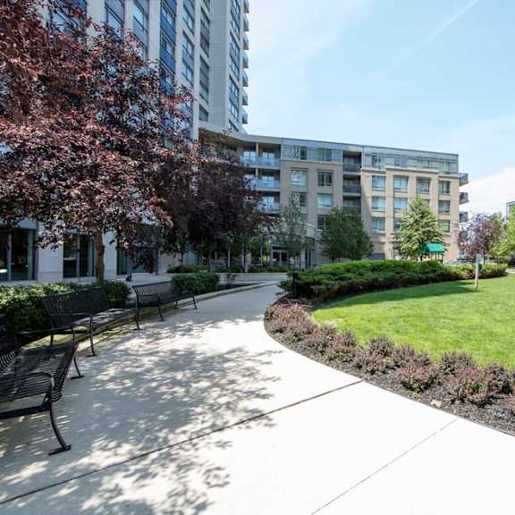 a park with benches and a grassy area in front of a building