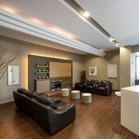 a living room with leather couches and stools