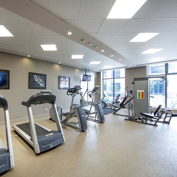 a gym with treadmills and other exercise equipment at trillium apartments in fairfax
