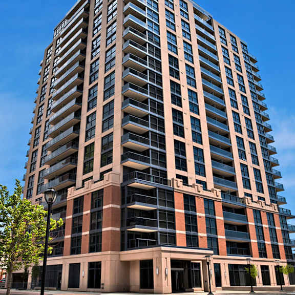 a tall building with balconies and a blue sky in the background