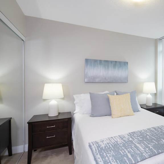 a bedroom with a large bed and two night stands with lamps