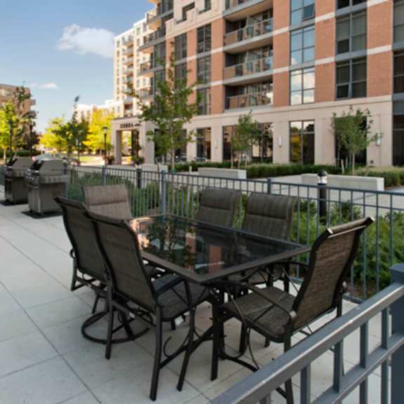a patio with a table and chairs in front of a building