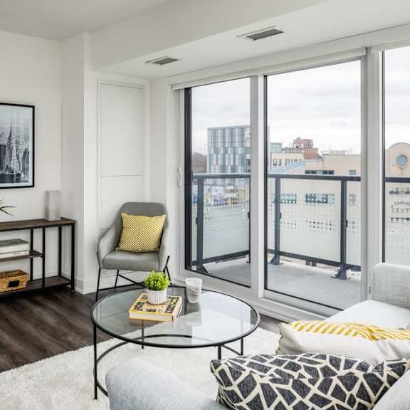 a living area with a couch coffee table and large windows