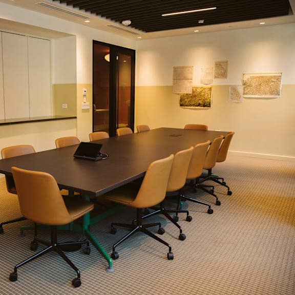 A conference room with a long table and chairs.