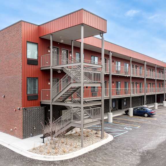 a red brick building with a parking lot in front.
