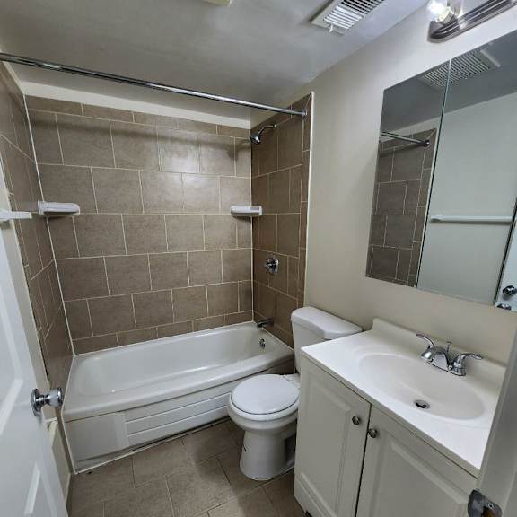 a white toilet sits next to a bathtub in a bathroom.