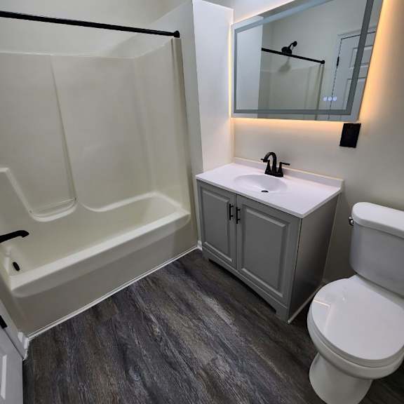 a bathroom with a white toilet, a sink, and a bathtub.