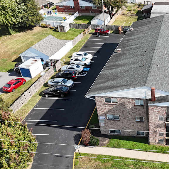 a parking lot with cars and a building in the background.