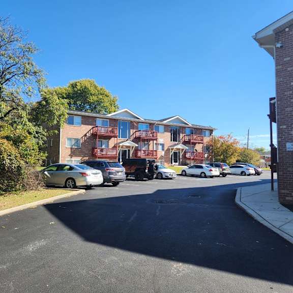 a street view of a residential area with cars parked on the side of the road.