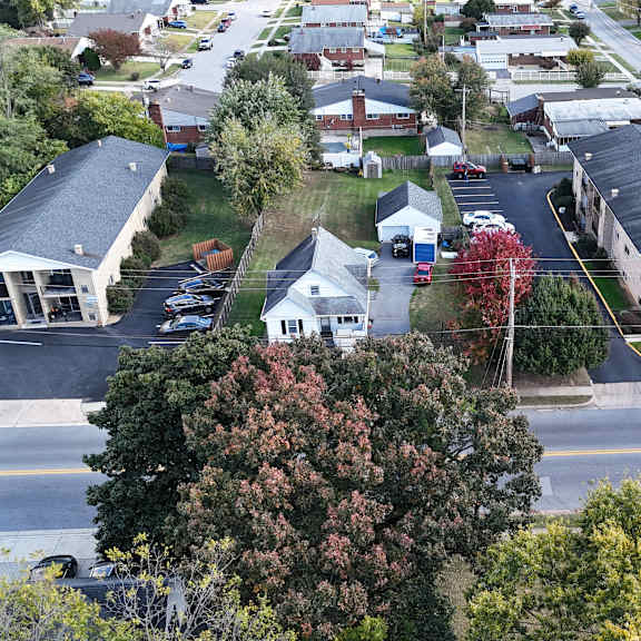 a street view of a residential area with houses and cars.