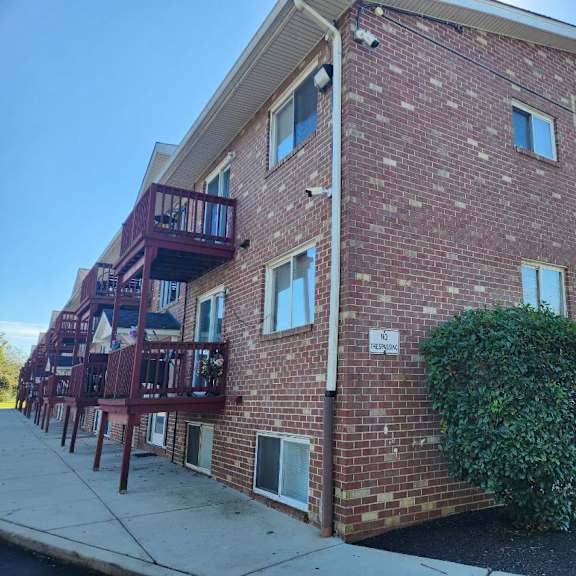 a red brick building with a balcony on the left side.