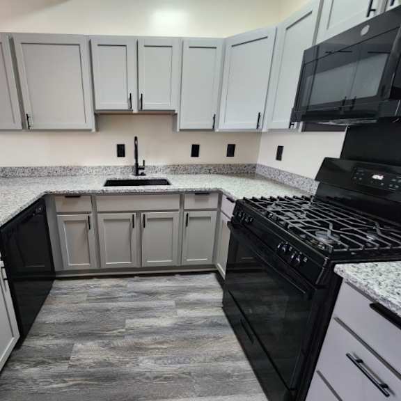 a kitchen with black appliances and white cabinets.