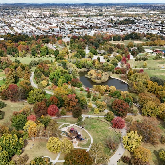 an aerial view of a park with a pond and a walking path.