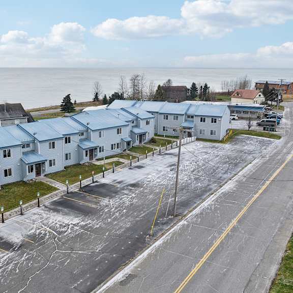 a row of houses with a road in front of them.
