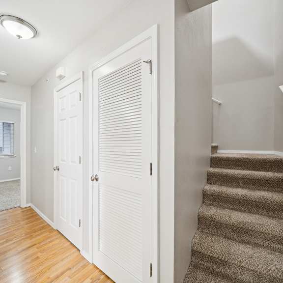 a hallway with a staircase and a window.