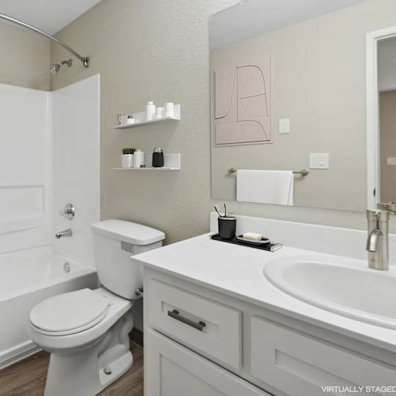 a white toilet sits next to a white sink in a bathroom.