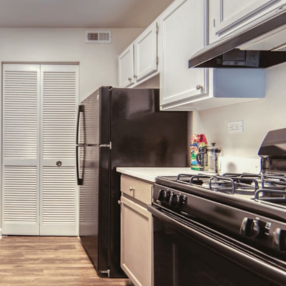 a kitchen with white cabinets and black appliances at the view apartments st charles, st charles, il