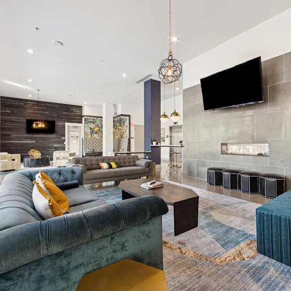a modern living area with a blue sofa and a fireplace.