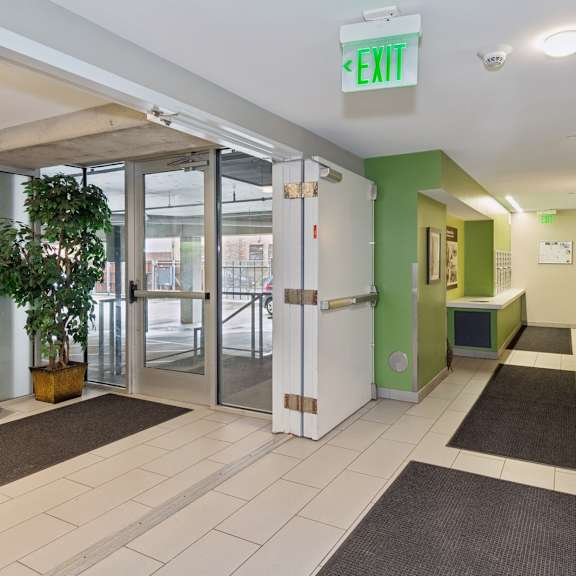 a hallway with a green exit sign at the top.