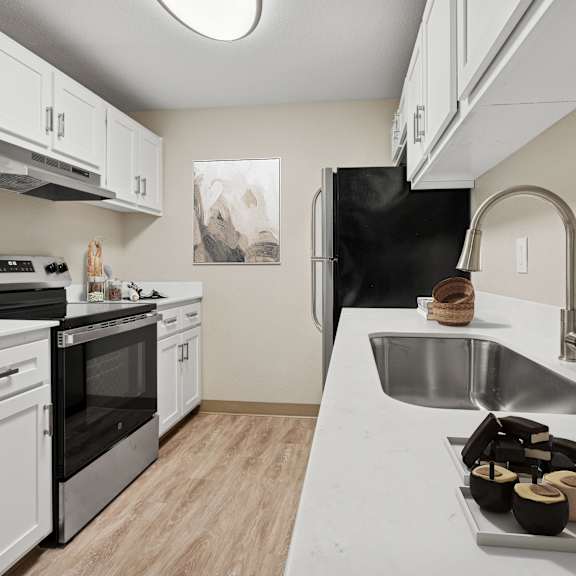 a kitchen with a black refrigerator, stove, and oven.
