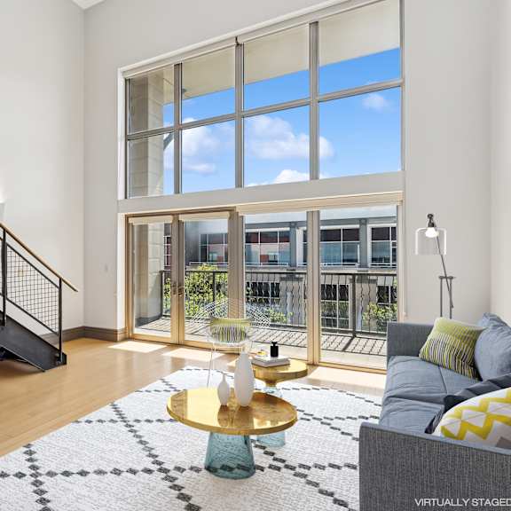 a living room with a staircase and a large window.