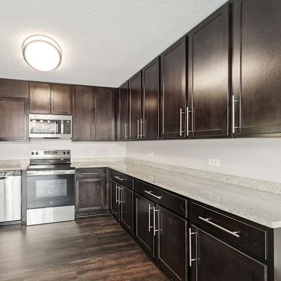 a kitchen with dark wood cabinets and stainless steel appliances.