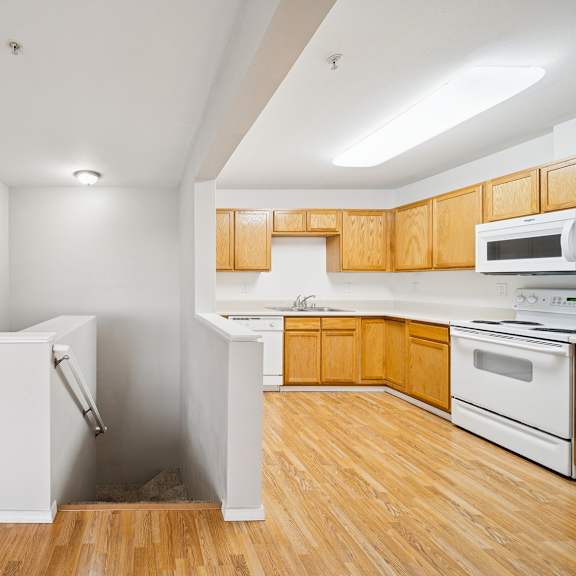 a kitchen with wooden cabinets and a white fridge.