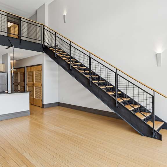 a kitchen with a staircase leading to the upper floor.