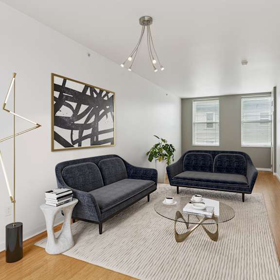 a living room with a black couch and a coffee table.